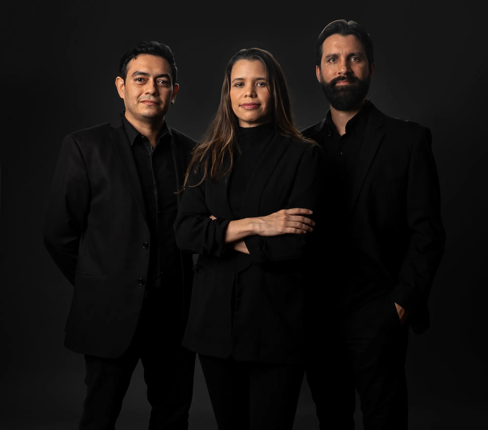 Israel Ramírez, Alejandra Molina y Mauricio Rosales, socios de Punto Arq, de pie sobre fondo negro.